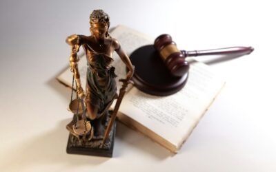 Statue of justice with gavel and open law book on table
