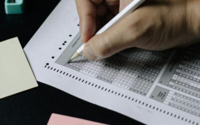 Student writing on test paper with pencil during examination