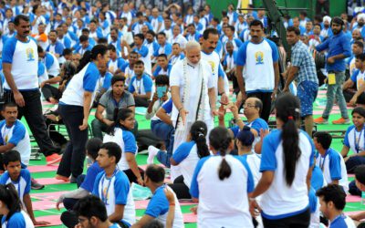 Participants performing yoga asanas outdoors during International Day of Yoga