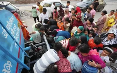 Residents queuing with containers around a water tanker during a city water shortage