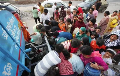 Residents queuing with containers around a water tanker during a city water shortage