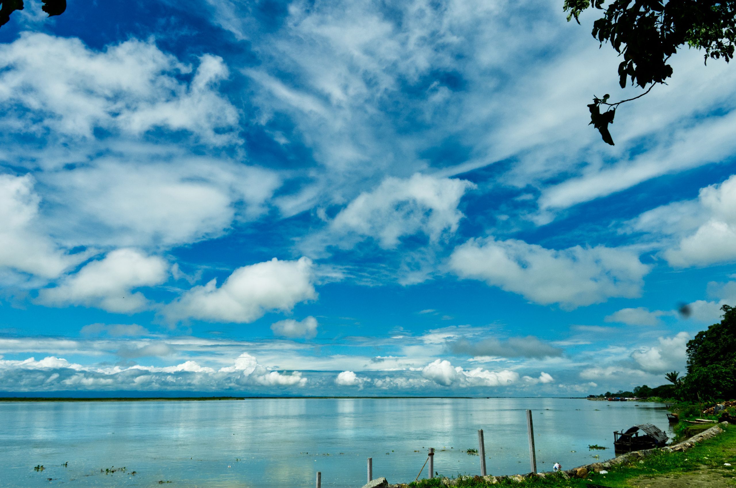 Wide view of the swollen Brahmaputra river from its bank in Dibrugarh, Assam