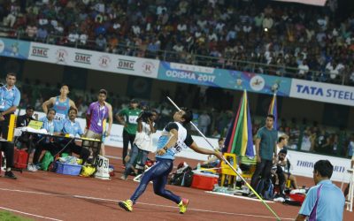 A javelin thrower in mid-throw action during an athletics competition