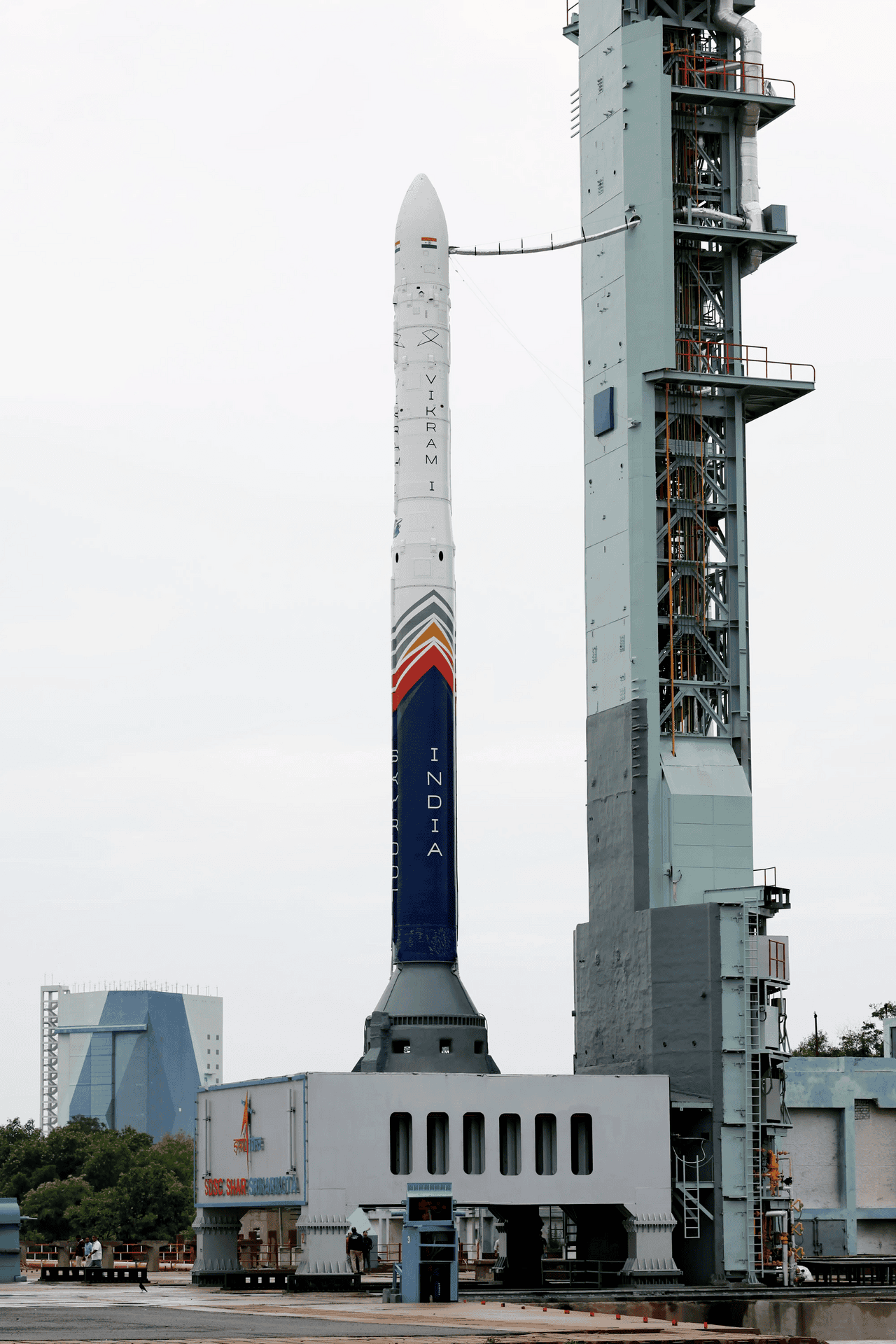 A private launch vehicle standing vertically on its launch pad at a spaceport