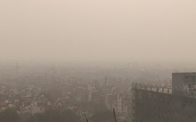 Hazy polluted skyline over Delhi with vehicles on a city road