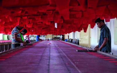 Workers at sewing machines on a textile factory floor in India