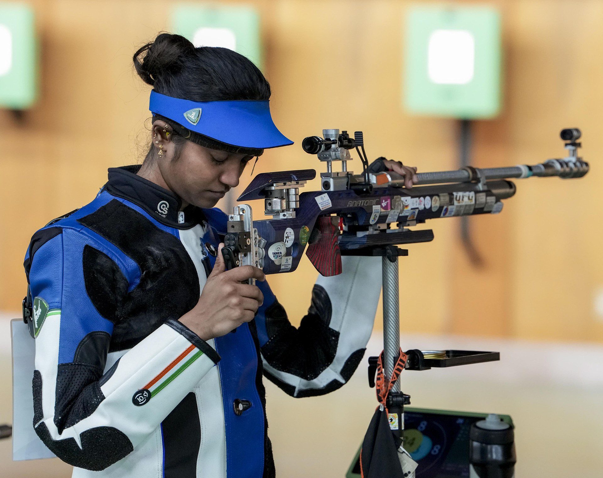 Indian woman shooter loading her air rifle at the Asian Games shooting range