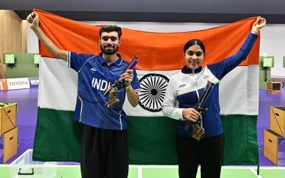 Two Indian pistol shooters hold up the Indian tricolour after winning the 10m air pistol mixed team gold