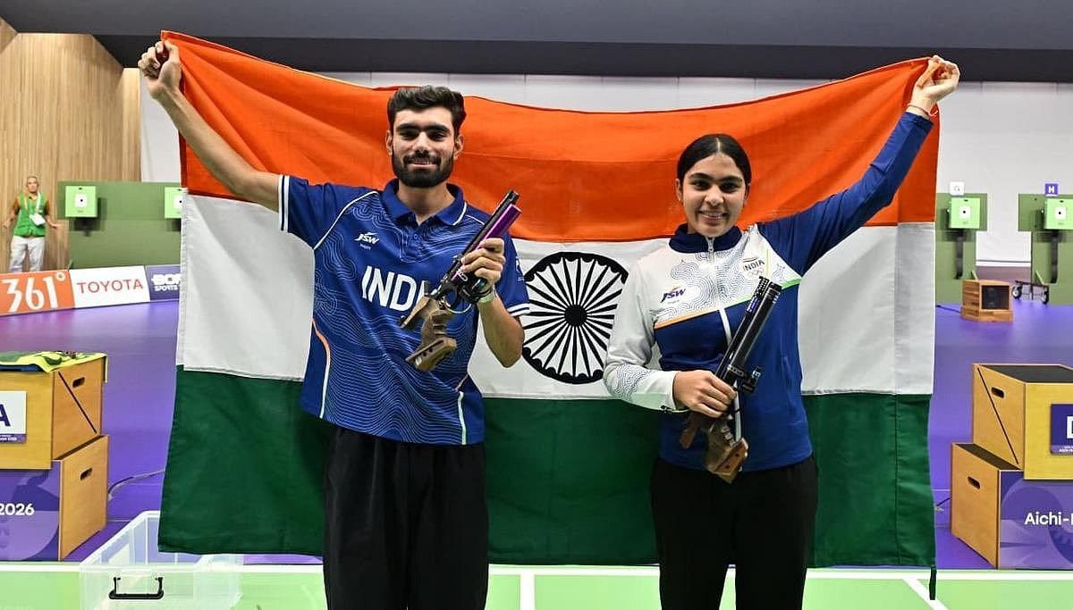 Two Indian pistol shooters hold up the Indian tricolour after winning the 10m air pistol mixed team gold