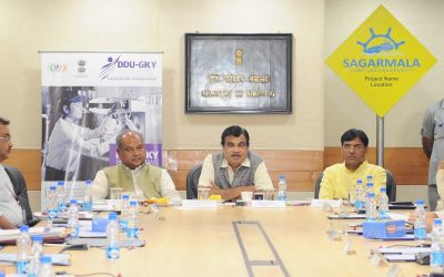 Officials at a signing ceremony with a DDU-GKY skill development banner in the background