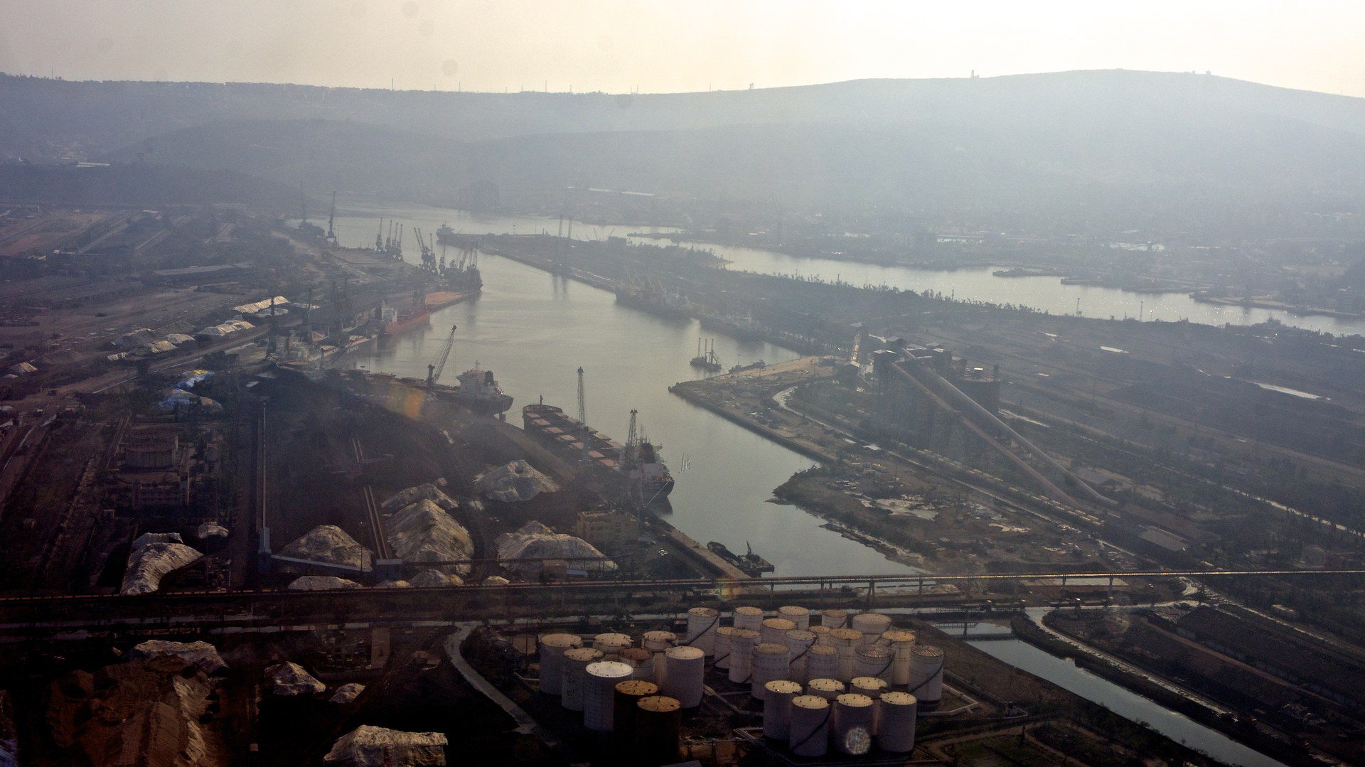 Aerial view of an Indian seaport with docks, cargo berths and breakwaters