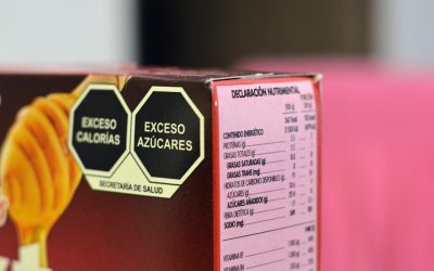 Black octagonal front-of-pack warning seals and a nutrition declaration panel printed on a packaged cereal box