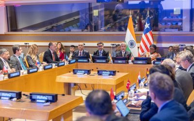 Delegates seated around a conference table at the United Nations with Indian and Liberian flags behind the chairs