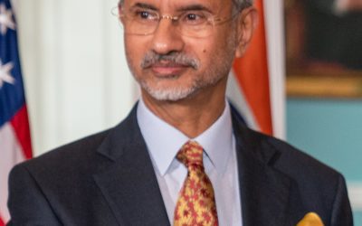 Portrait of India's External Affairs Minister standing before the Indian tricolour at an official event