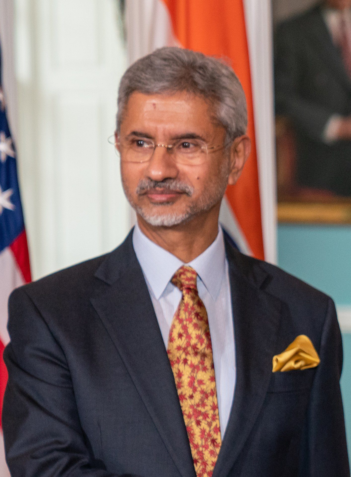 Portrait of India's External Affairs Minister standing before the Indian tricolour at an official event