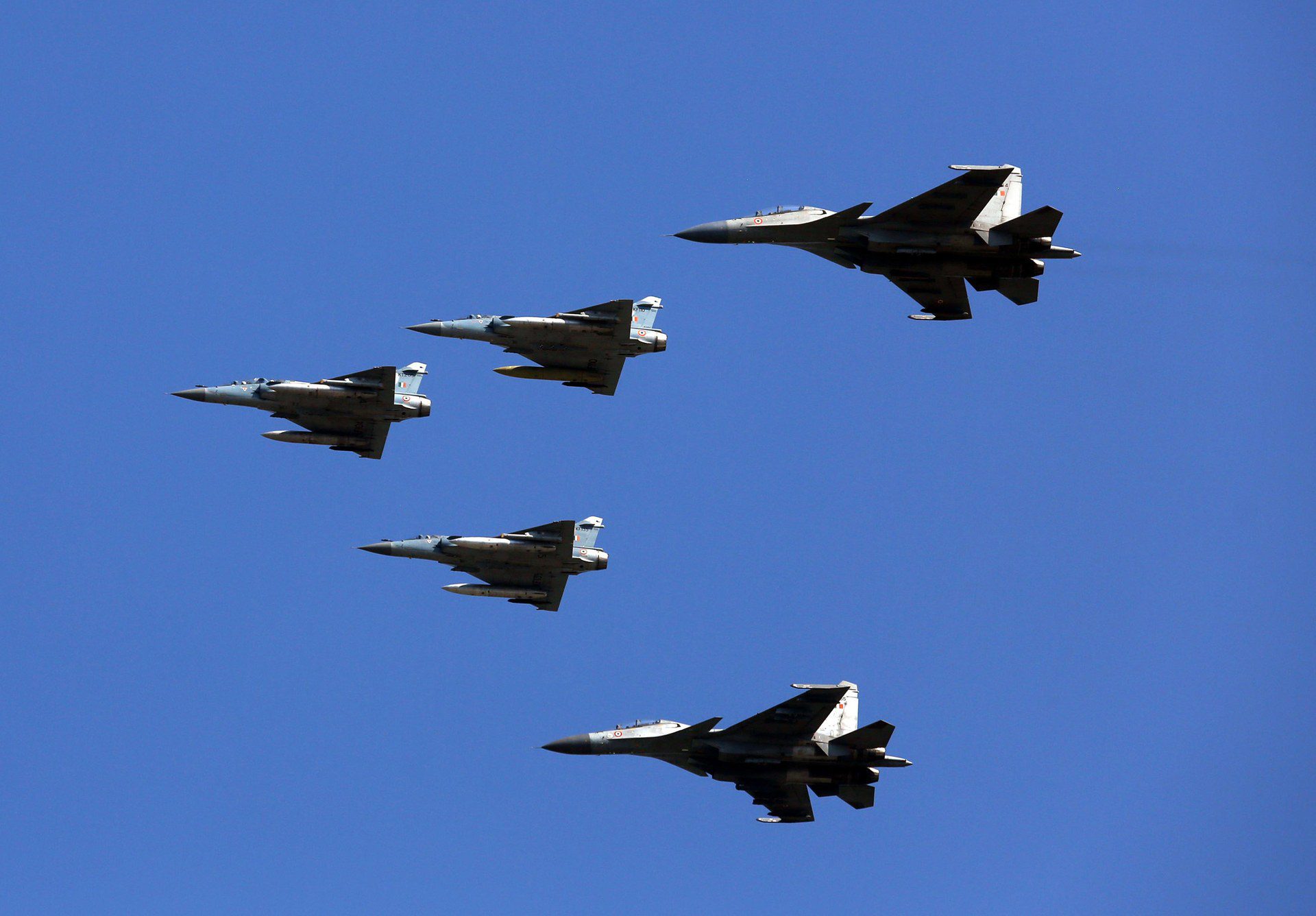 Indian Air Force Su-30 MKI and Mirage 2000 fighter aircraft flying in formation against a clear blue sky