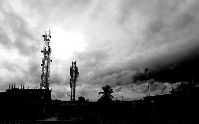 Mobile phone towers against a cloudy sky in India