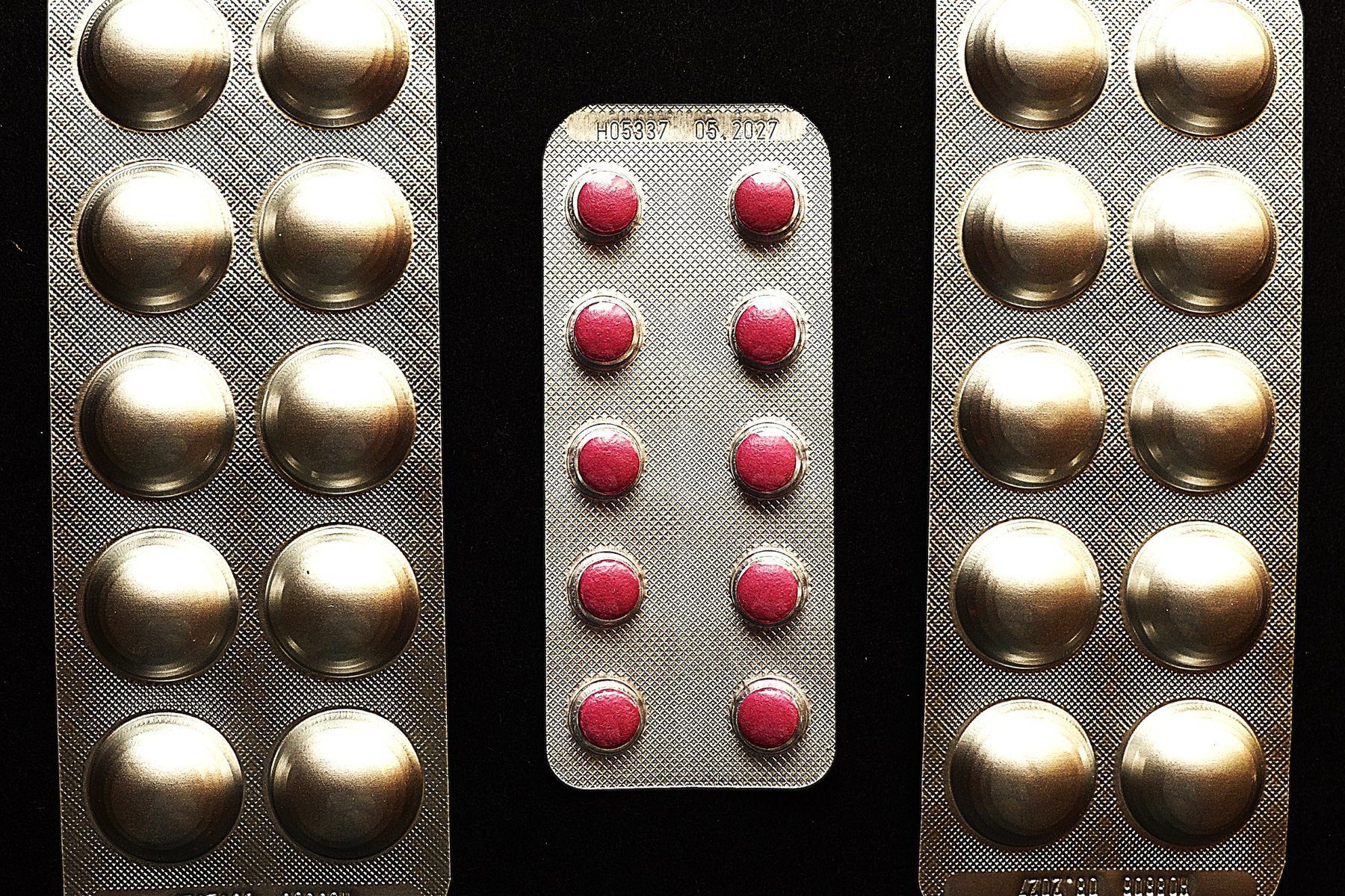 Blister packs of tablets on a dark background, a representative image of medicines