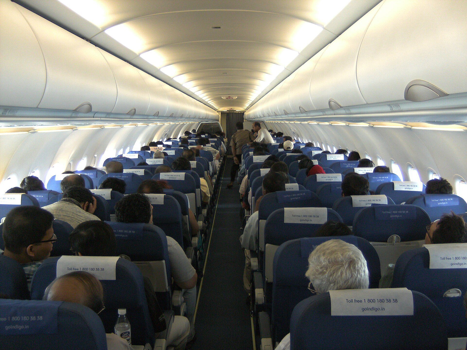 Passenger cabin of an Airbus A320 with overhead bins above the seat rows