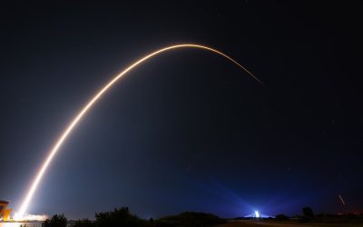 Long-exposure photo of a Falcon 9 rocket carrying Starlink satellites lifting off at night