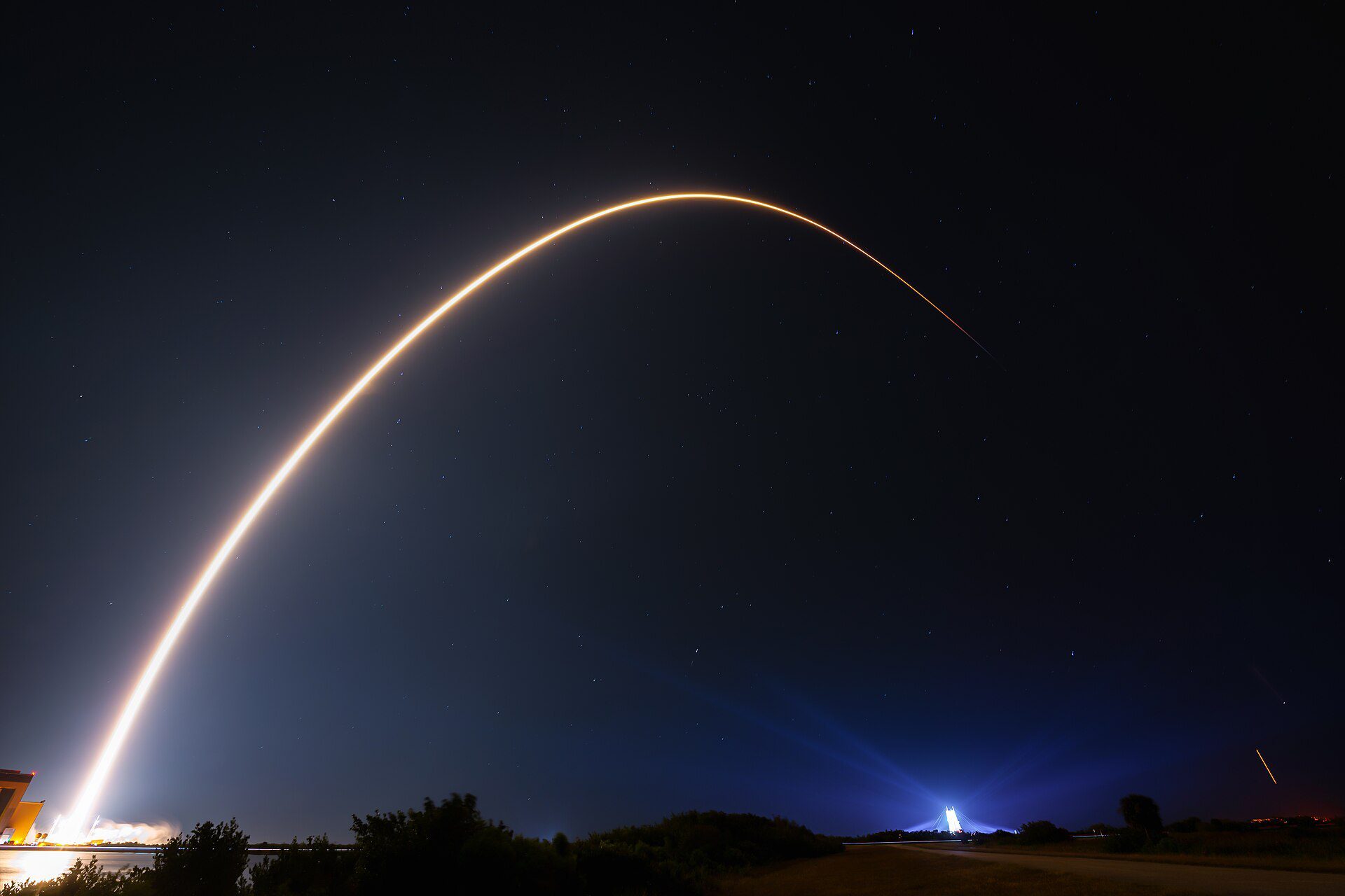 Long-exposure photo of a Falcon 9 rocket carrying Starlink satellites lifting off at night